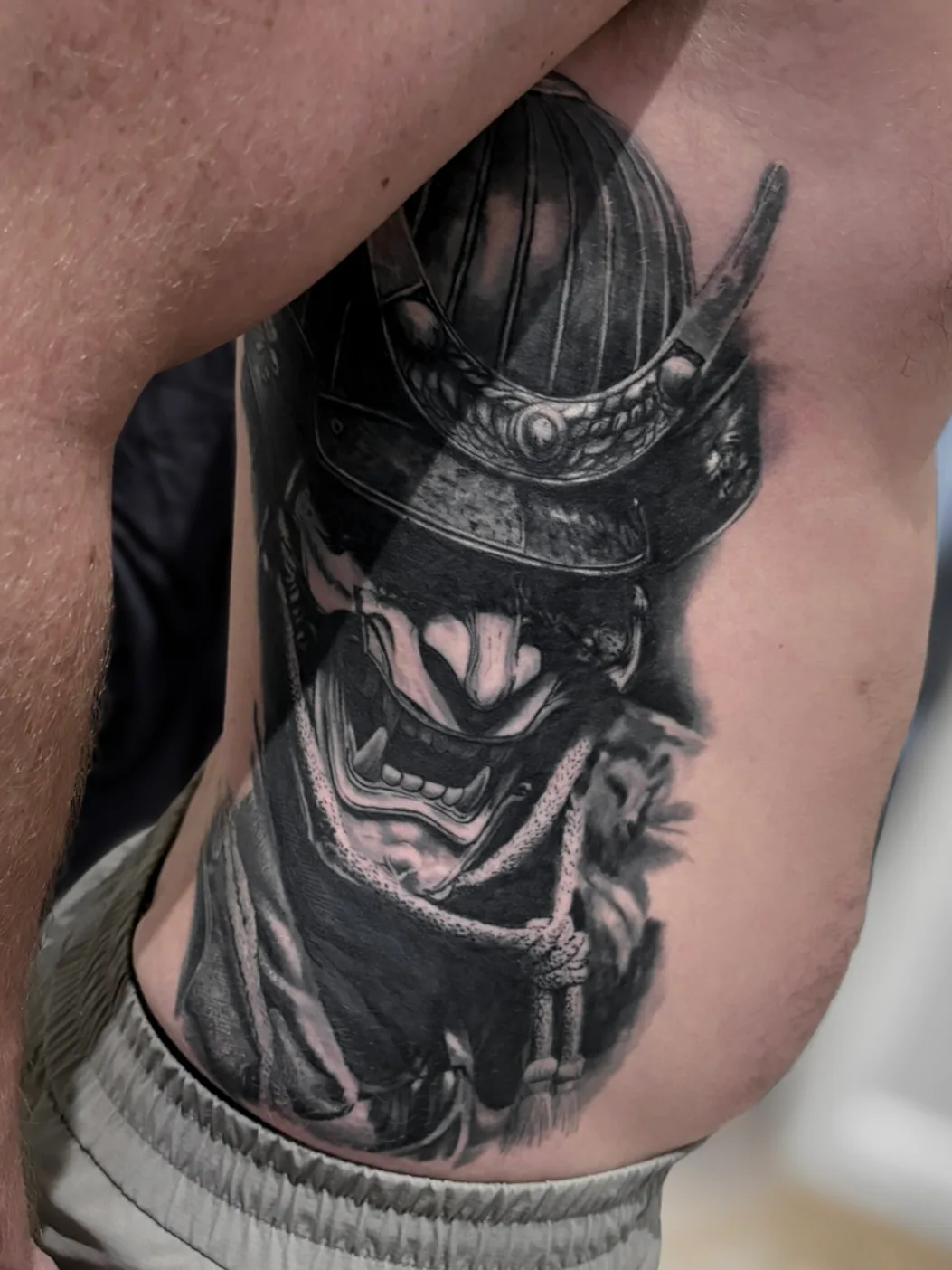 Confirmed healed black and grey warrior mask portrait tattoo by Vladimir Vishar