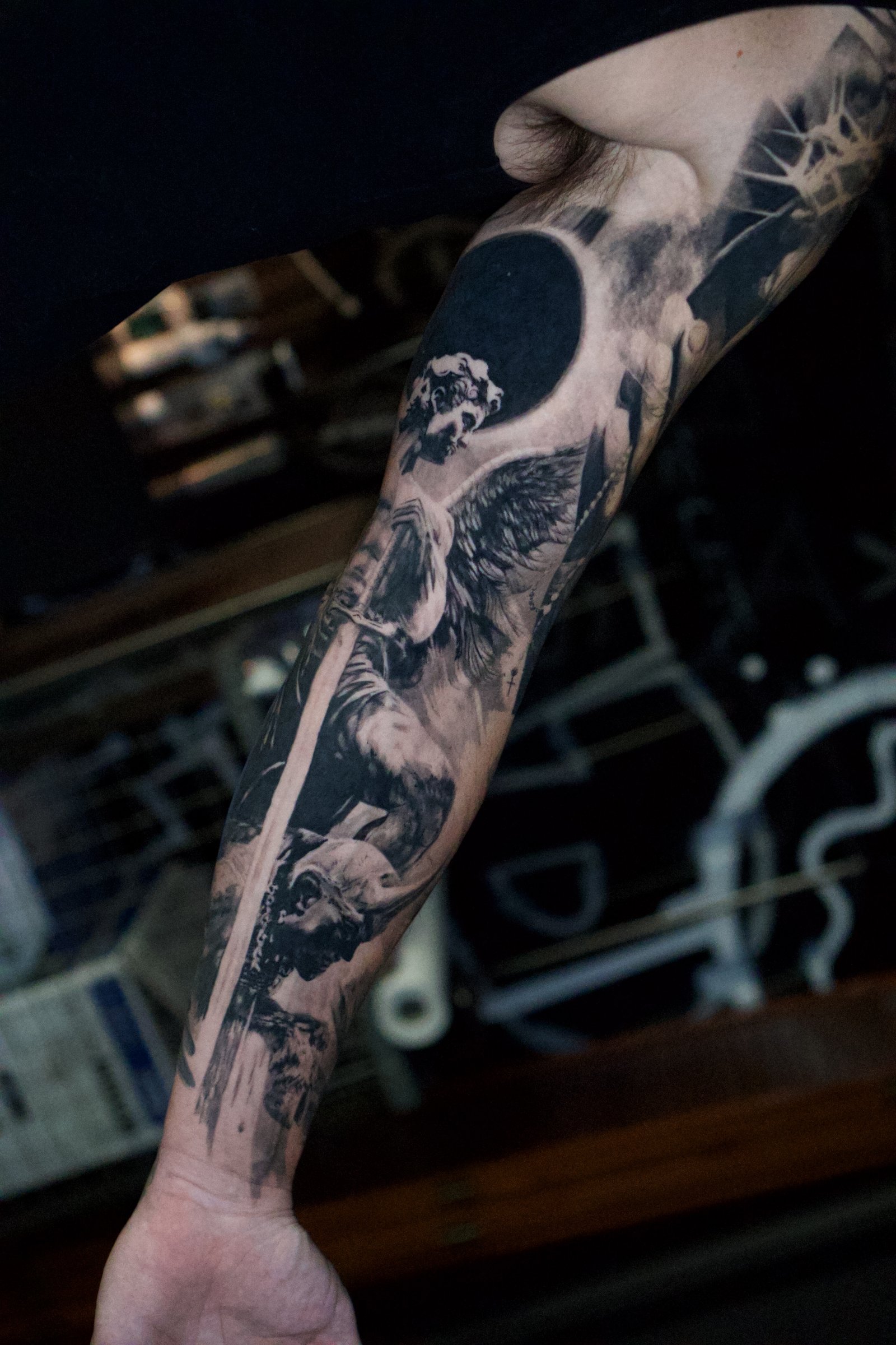 Large-scale black and grey realism sleeve photographed on the arm